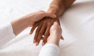 Masseuse making acupuncture hand massage for black woman
